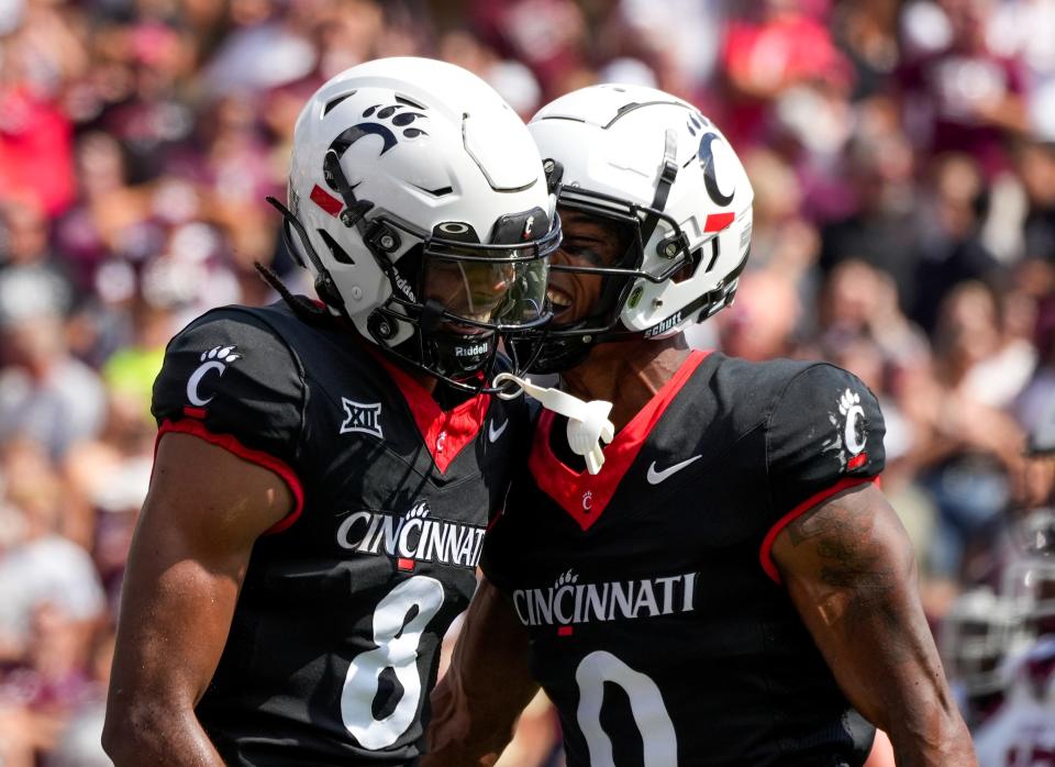 Cincinnati Bearcats wide receiver Xzavier Henderson (8) and Cincinnati Bearcats wide receiver Braden Smith (0) celebrate after Henderson scores a touchdown during the first quarter of the NCAA football game between the Cincinnati Bearcats and the Eastern Kentucky Colonels at Nippert Stadium in Cincinnati on Saturday, Sept. 2, 2023.