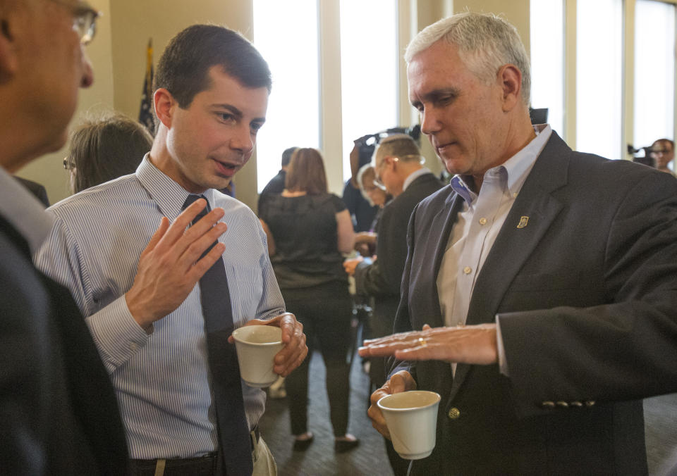 FILE - In this May 1, 2015, file photo, then-Indiana Gov. Mike Pence, right, talks with South Bend Mayor Pete Buttigieg during a visit to recap the legislative session that ends in South Bend. Democratic presidential candidate Pete Buttigieg blasts Vice President Mike Pence’s religious conservatism. But as the mayor of South Bend, Indiana, his tone toward the state’s former governor was more muted. The two once had a cordial relationship. (Robert Franklin/South Bend Tribune via AP)