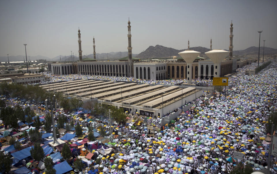 Muslim pilgrims hold umbrellas