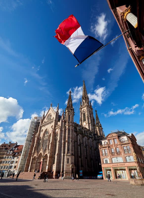 People walk in front of the Saint-Etienne church in Mulhouse