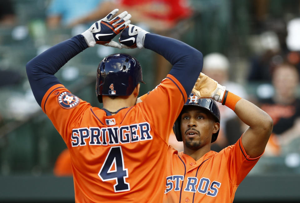 Houston Astros' Tony Kemp, right, high-fives teammate George Springer after scoring on Springer's two-run home run in the sixth inning of the first baseball game of a doubleheader against the Baltimore Orioles, Saturday, Sept. 29, 2018, in Baltimore. (AP Photo/Patrick Semansky)