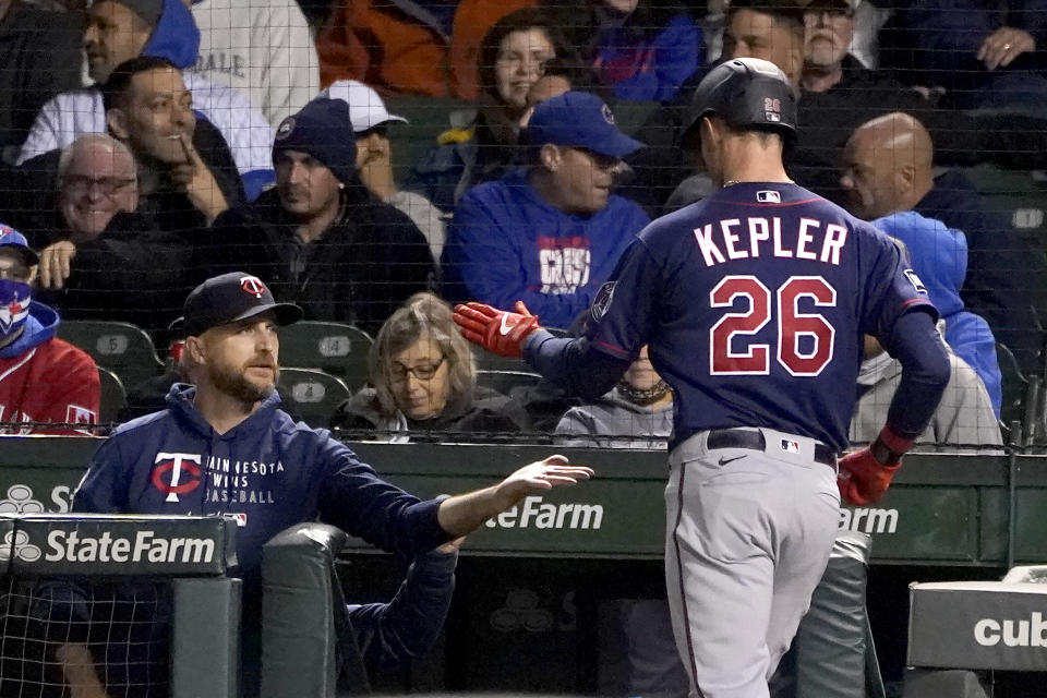 Minnesota Twins manager Rocco Baldelli, left, greets Max Kepler at the dugout after Kepler's home run off Chicago Cubs starting pitcher Kyle Hendricks during the fourth inning of a baseball game Wednesday, Sept. 22, 2021, in Chicago. (AP Photo/Charles Rex Arbogast)