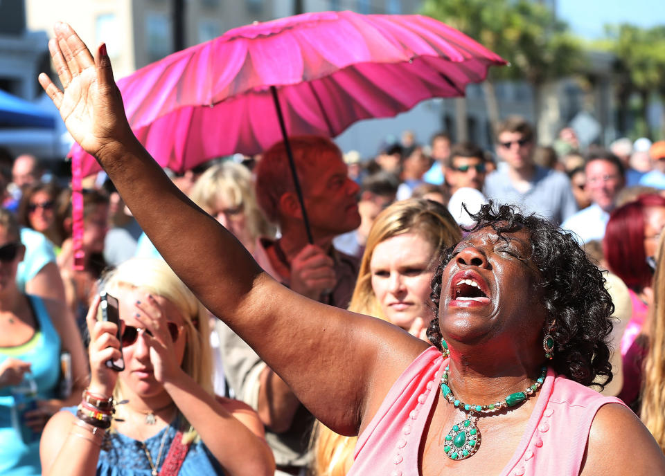 CHARLESTON, SC - JUNE 21:  Deborah Johnson prays in front of the Emanuel African Methodist Episcopal Church as she listens to a broadcast of the Sunday service taking place after a mass shooting at the church killed nine people on June 21, 2015 in Charleston, South Carolina. Dylann Roof, 21 years old, is suspected of killing the nine people during a prayer meeting in the church, which is one of the nation's oldest black churches in Charleston.  (Photo by Joe Raedle/Getty Images)