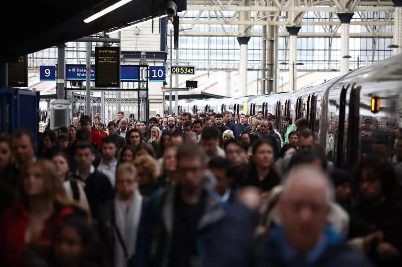 Commuters walk along a packed platform after a single train arrived during the morning rush hour, at Waterloo Station