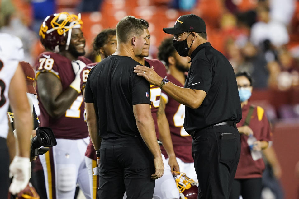 Cincinnati Bengals coach Zac Taylor, center and Washington Football Team coach Ron Rivera talk after a preseason NFL football game Friday, Aug. 20, 2021, in Landover, Md. Washington won 17-13. (AP Photo/Susan Walsh)