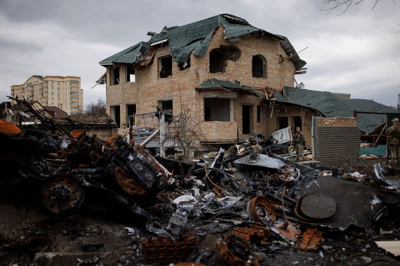 Ukrainian soldiers inspect a destroyed house, amid Russia's invasion of Ukraine, in Bucha