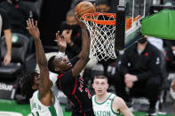 Toronto Raptors guard Terence Davis (0) shoots after grabbing a rebound against Boston Celtics center Robert Williams III, left, during the first half of an NBA basketball game, Thursday, March 4, 2021, in Boston. At right is Boston Celtics guard Payton Pritchard. (AP Photo/Charles Krupa)