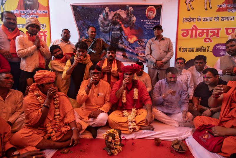 Members of All India Hindu Mahasabha drink cow urine as they attend gaumutra (cow urine) party, which according to them helps warding off COVID-19, in New Delhi