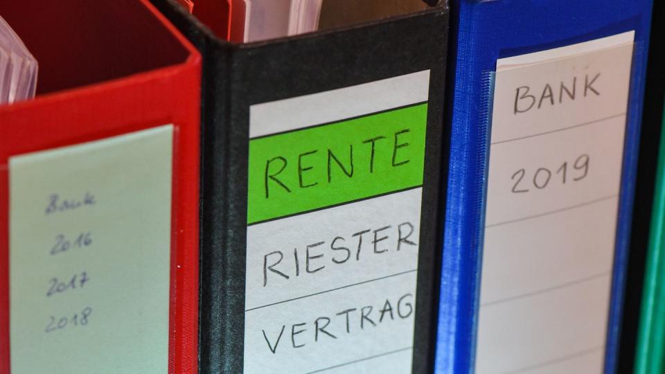 ILLUSTRATION - Ein Ordner mit der Aufschrift «Rente Riester Vertrag» steht zwischen anderen Aktenordnern.