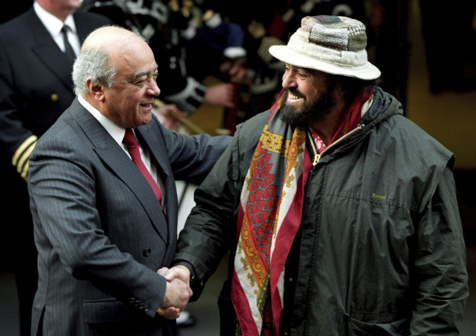 FILE - The late Italian tenor Luciano Pavarotti, right, greeted by the then Harrods boss Mohamed Al Fayed as he arrives at the Knightsbridge store, in London, April 19, 1995. Al Fayed, the former Harrods owner whose son Dodi was killed in a car crash with Princess Diana, has died at age 94. His death was announced Friday, Sept. 1, 2023, by Fulham Football Club, which Al Fayed once owned. (PA/PA Wire via AP, File)