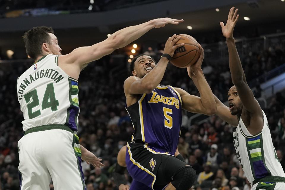 Los Angeles Lakers' Talen Horton-Tucker drives between Milwaukee Bucks' Pat Connaughton and Khris Middleton during the first half of an NBA basketball game Wednesday, Nov. 17, 2021, in Milwaukee. (AP Photo/Morry Gash)