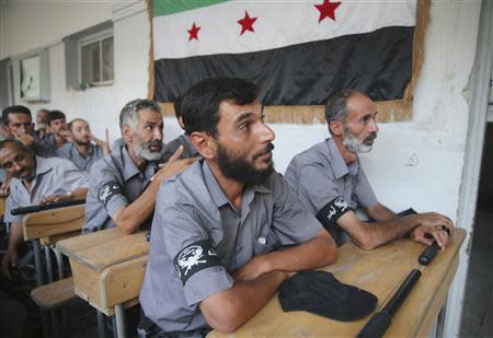 Recruits attend a class to be trained as part of a police battalion under the Free Syrian Army's 'Farouq Omar Brigade' at their headquarters in the Duma neighbourhood of Damascus September 11, 2013. REUTERS/Mohamed Abdullah