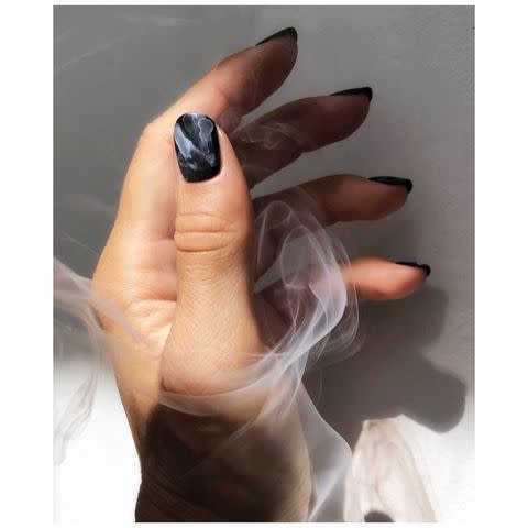 <p>While your black base coat is still wet, <strong>swirl a few drops of <a href="https://www.amazon.com/OPI-Nail-Lacquer-Alpine-Snow/dp/B002D4DQ1Q?tag=syn-yahoo-20&ascsubtag=%5Bartid%7C10049.g.35129259%5Bsrc%7Cyahoo-us" rel="nofollow noopener" target="_blank" data-ylk="slk:white nail polish;elm:context_link;itc:0;sec:content-canvas" class="link ">white nail polish</a> into the <a href="https://lapierrecosmetics.com/shop/pot-hole" rel="nofollow noopener" target="_blank" data-ylk="slk:black nail polish;elm:context_link;itc:0;sec:content-canvas" class="link ">black nail polish</a></strong> to create a smoky or <a href="https://www.cosmopolitan.com/style-beauty/beauty/how-to/a29986/nail-art-how-to-marble-manicure/" rel="nofollow noopener" target="_blank" data-ylk="slk:marbled effect;elm:context_link;itc:0;sec:content-canvas" class="link ">marbled effect</a> like this.</p><p><a href="https://www.instagram.com/p/CGsLKLajrTw/?utm_source=ig_embed&utm_campaign=loading" rel="nofollow noopener" target="_blank" data-ylk="slk:See the original post on Instagram;elm:context_link;itc:0;sec:content-canvas" class="link ">See the original post on Instagram</a></p>