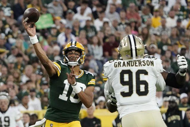 Green Bay Packers quarterback Jordan Love (10) passes under pressure from New Orleans Saints defensive end Carl Granderson (96) during the first half of a preseason NFL football game Friday, Aug. 19, 2022, in Green Bay, Wis. (AP Photo/Morry Gash)