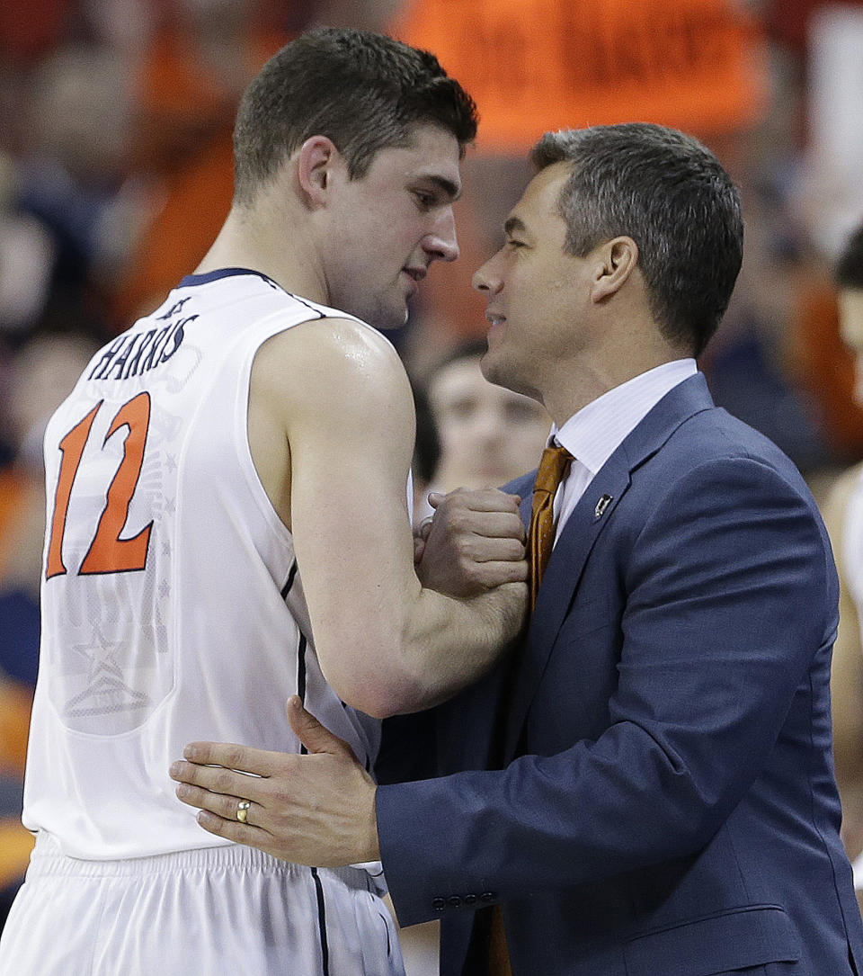 Memphis forward David Pellom (12) embraces Virginia head coach Tony Bennett during the second half of an NCAA college basketball third-round tournament game against Memphis, Sunday, March 23, 2014, in Raleigh, N.C. (AP Photo/Gerry Broome)