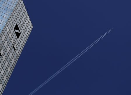 A plane flies above the headquarters of Germany's Deutsche Bank in Frankfurt