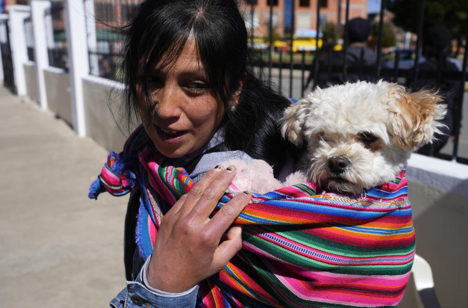 Una mujer asiste con su perro a una misa en la iglesia del Cuerpo de Cristo por las celebraciones del día de San Roque, considerado el santo patrón de los perros, en El Alto, Bolivia, el miércoles 16 de agosto de 2023. (AP Foto/Juan Karita)