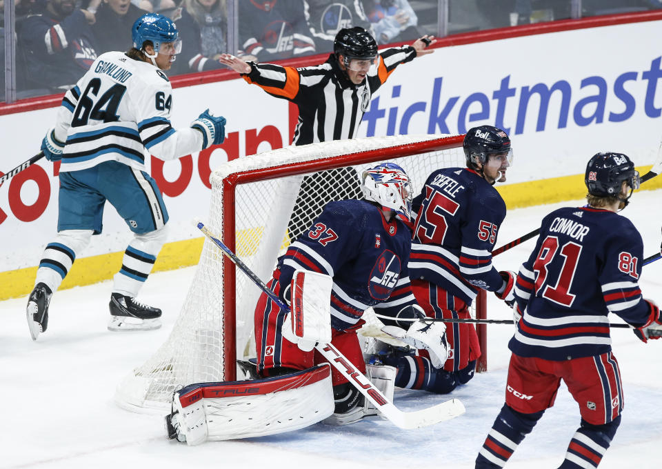 A referee calls off an apparent San Jose Sharks goal against the Winnipeg Jets during the second period of an NHL hockey game Wednesday, Feb. 14, 2024, in Winnipeg, Manitoba. (John Woods/The Canadian Press via AP)