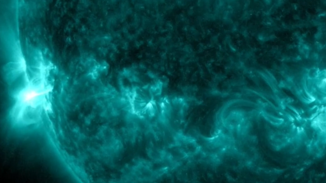  a close-up of the sun in false color wavelengths, with a burst of flare on the left limb 