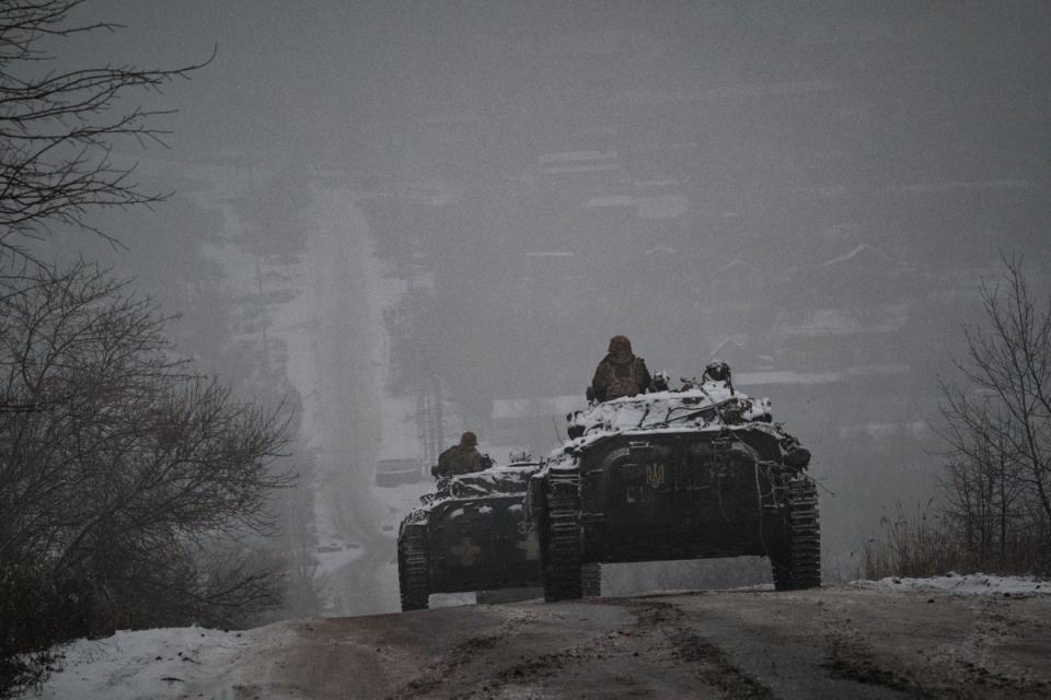 Ukrainian servicemen ride atop BMP-2 infantry combat vehicles driving down an icy road in the Donetsk region (AFP via Getty Images)