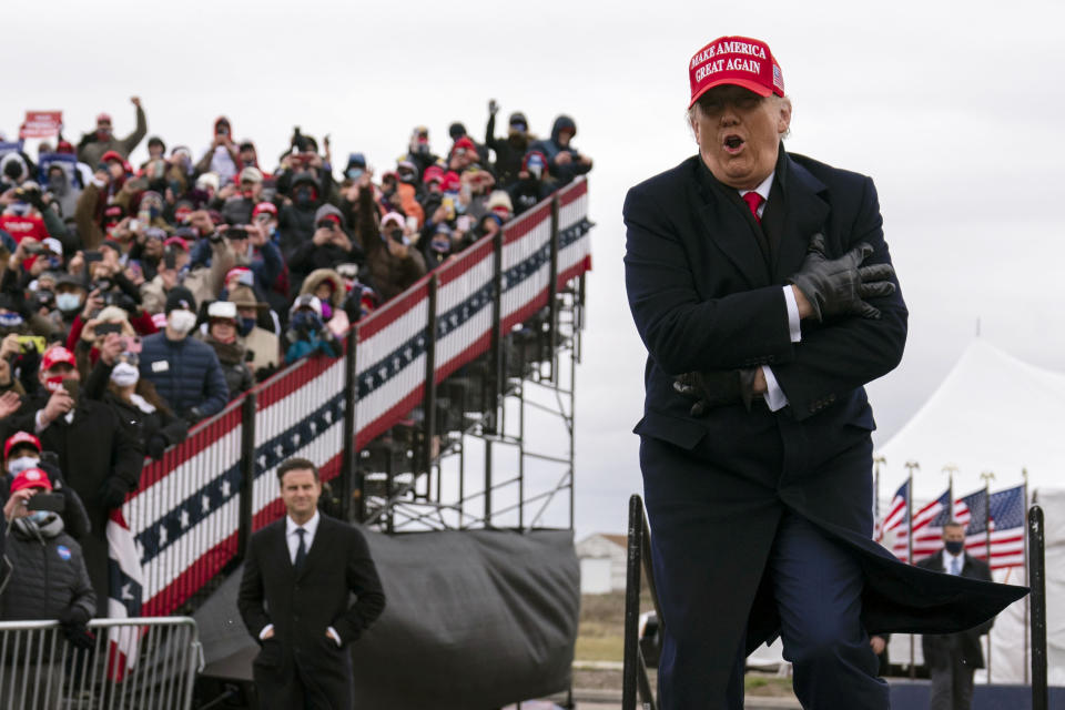 President Donald Trump jokes about the cold as he arrives for a campaign rally at Michigan Sports Stars Park, Sunday, Nov. 1, 2020, in Washington, Mich. (AP Photo/Evan Vucci)