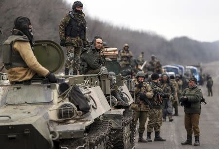 Members of the Ukrainian armed forces and armoured personnel carriers are seen preparing to move as they pull back from Debaltseve region, near Artemivsk February 26, 2015. REUTERS/Gleb Garanich