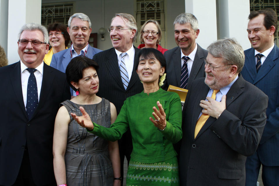 Myanmar opposition leader Aung San Suu Kyi, center, poses for a photo with Werner Langen, left, a German member of the European parliament and group members from a delegation on relations with countries belonging to The Association of Southeast Asian Nations, ASEAN, at her lake side home Wednesday, Feb. 29, 2012, in Yangon, Myanmar. (AP Photo/Khin Maung Win)