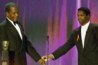 Sidney Poitier (esq.) é parabenizado pelo ator Denzel Washington (dir.) ao receber o prêmio honorário "Life Achievement" do Sindicato dos Atores (SAG) em Los Angeles, 12 de março de 2000 (AFP/LUCY NICHOLSON)