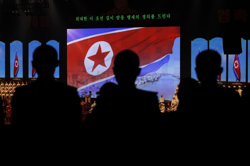 North Koreans military cadets are silhouetted near the North Korean flag as they attend an evening gala held on the eve of the 70th anniversary of North Korea's founding day in Pyongyang, North Korea, Saturday, Sept. 8, 2018. North Korea will be staging a major military parade, huge rallies and reviving its iconic mass games on Sunday to mark its 70th anniversary as a nation. (AP Photo/Kin Cheung)