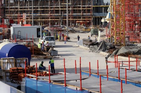 FILE PHOTO: Migrant labourers work at a construction site in Doha, Qatar