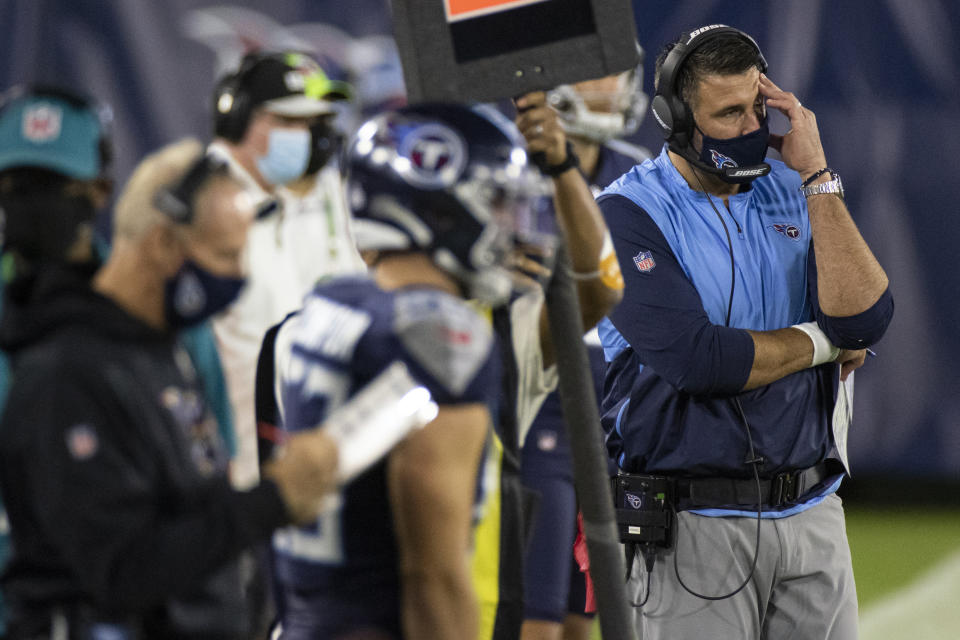 FILE- In this Oct. 13, 2020, file photo, Tennessee Titans head coach Mike Vrabel, right, reacts during the second quarter of an NFL football game against the Buffalo Bills, in Nashville, Tenn. The NFL and the NFL Players Association found instances when the Titans failed to wear masks at all times and were “insufficiently clear” to players about not meeting or working out once the facility closed in a review given to the team Monday, Oct. 19, 2020, a person familiar with the investigation told The Associated Press. But the person familiar with the review says there was no discussion of any discipline for an individual including general manager Jon Robinson, coach Mike Vrabel or any players, and there was no discussion of punishment, including forfeitures or draft picks. (AP Photo/Brett Carlsen, File)