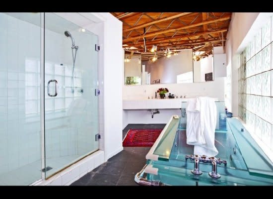 The glass-enclosed bathtub is reminiscent of a super-futuristic fish tank.