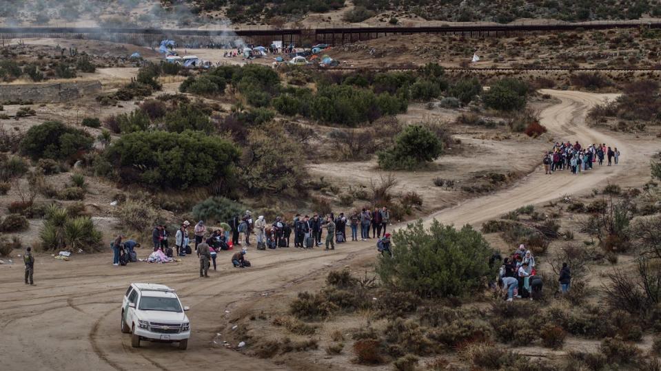 Migrants wait to be processed by U.S. Border Patrol agents near the U.S.-Mexico border in Jacumba Hot Springs, Calif. <a href="https://www.gettyimages.com/detail/news-photo/migrants-wait-to-be-processed-by-the-u-s-border-patrol-news-photo/1876398361?adppopup=true" rel="nofollow noopener" target="_blank" data-ylk="slk:Qian Weizhong/VCG via Getty Images;elm:context_link;itc:0;sec:content-canvas" class="link ">Qian Weizhong/VCG via Getty Images</a>