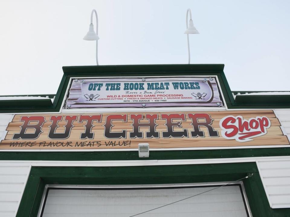 A sign for Off the Hook Meatworks photographed in Whitehorse on Dec. 31, 2020. The shop's owner is facing a charge of selling or distributing cannabis without a licence after jerky tainted with THC was sold to the public in late 2020. A new business now occupies the building. (Jackie Hong/CBC - image credit)