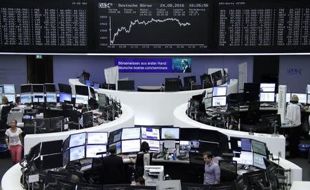 Traders work at their desks in front of the German share price index, DAX board, at the stock exchange in Frankfurt, Germany, August 24, 2016. REUTERS/Staff/Remote