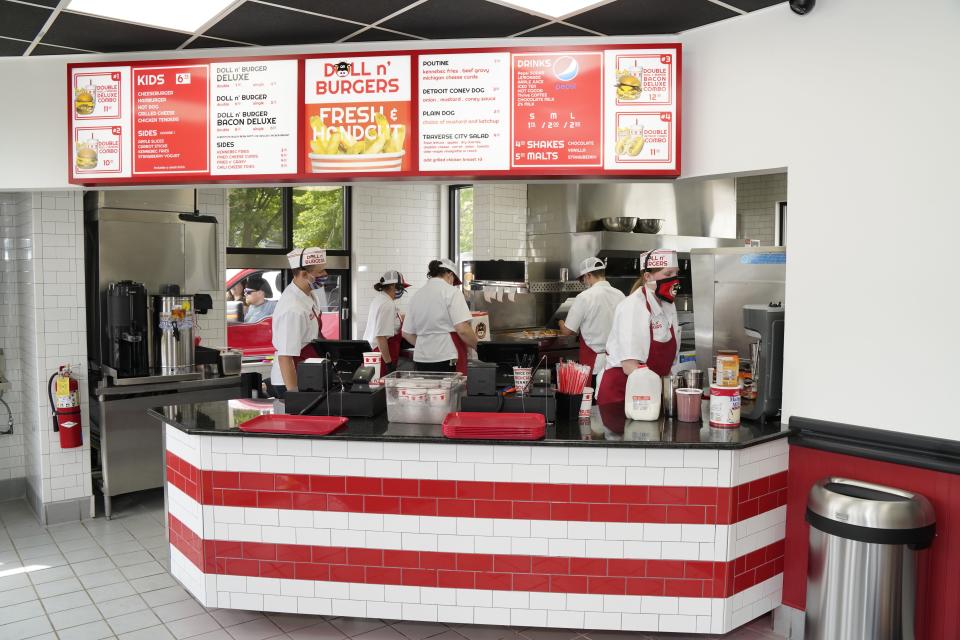 Doll n' Burgers employees prepare food on the Tecumseh restaurant's opening day, May 23, 2020.