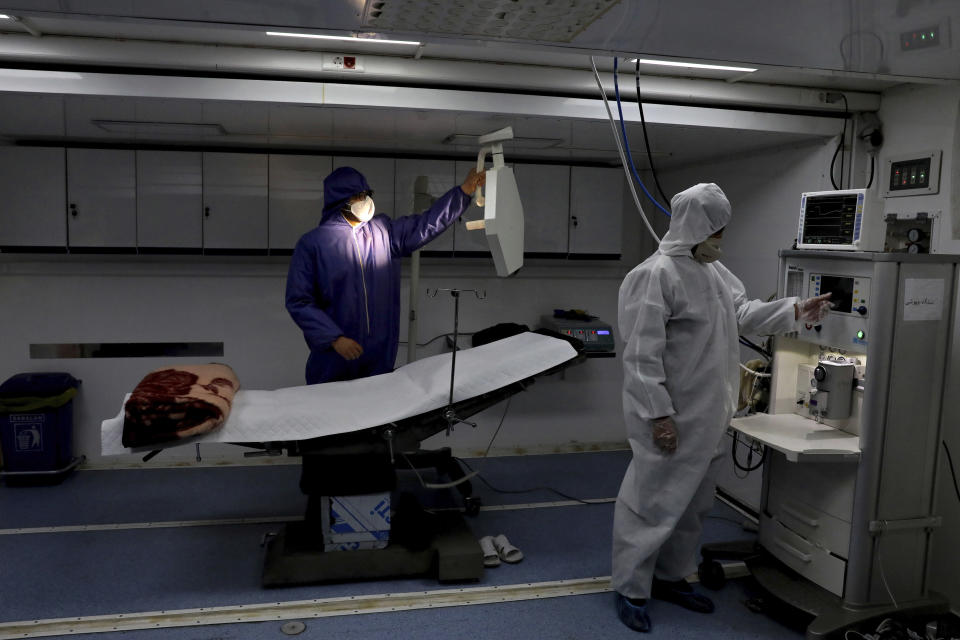 People in protective clothing work in a temporary 2,000-bed hospital for COVID-19 coronavirus patients set up by the Iranian army at the international exhibition center in northern Tehran, Iran, on Thursday, March 26, 2020. (AP Photo/Ebrahim Noroozi)