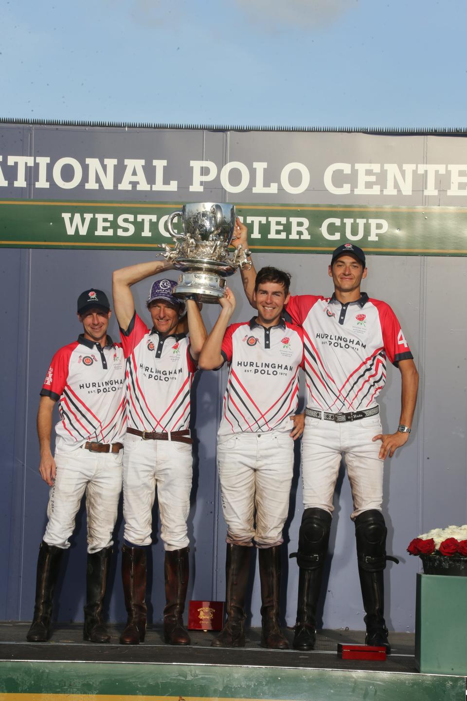 England's polo team celebrates defeating the U.S. while holding up the Westchester Cup Friday at National Polo Center.