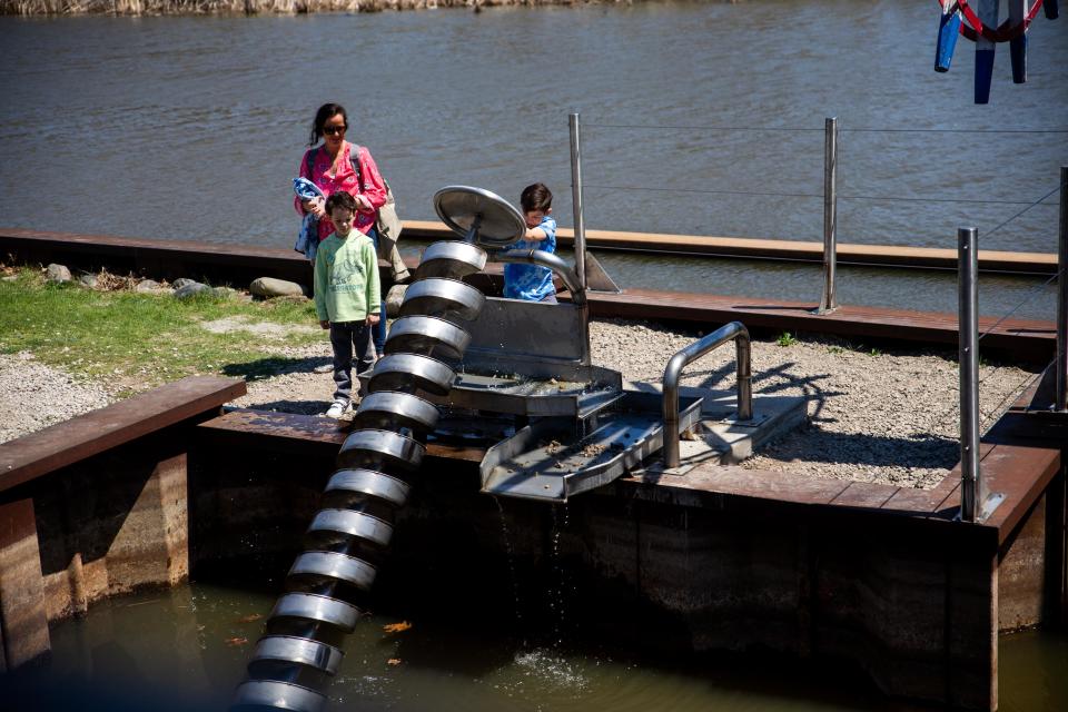 Children play with the new installation at Windmill Island Gardens Monday, May 9, 2022. The exhibit demonstrates the transport of water from the stream up the corkscrew. 