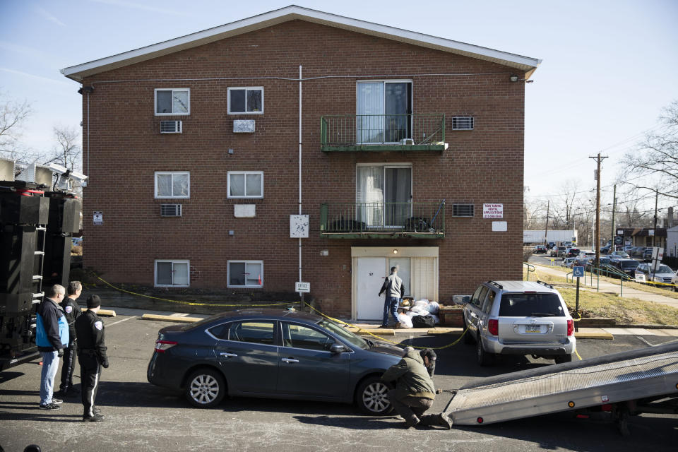 A car is taken from the crime scene at the Robert Morris Apartments in Morrisville, Philadelphia on Tuesday where a family of five were killed inside. Source: AP Photo/Matt Rourke