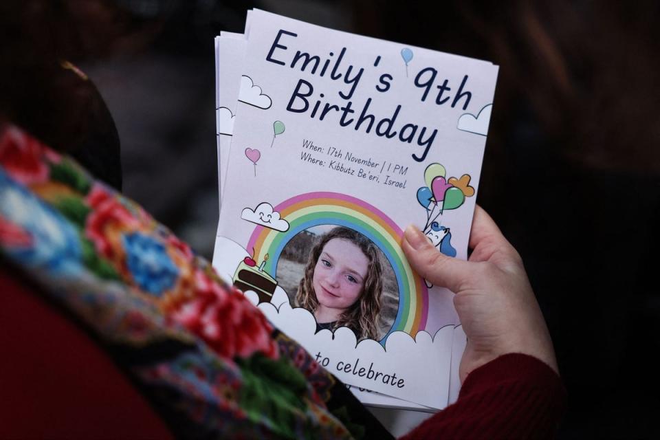 A woman holds leaflets picturing Irish-Israeli girl Emily Hand held hostage by Palestinian militant group Hamas in Gaza during a gathering for her 9th birthday (AFP via Getty Images)