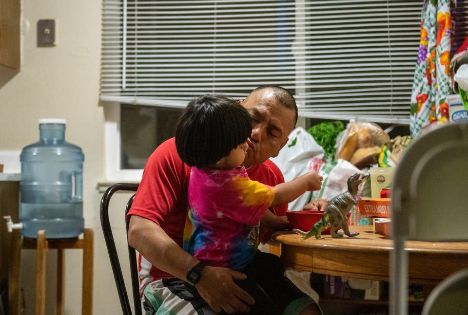 Meliton Salvador, right, tries to give his youngest son a kiss on the cheek as they both sit in the kitchen of their Salinas apartment on Saturday, May 16, 2020