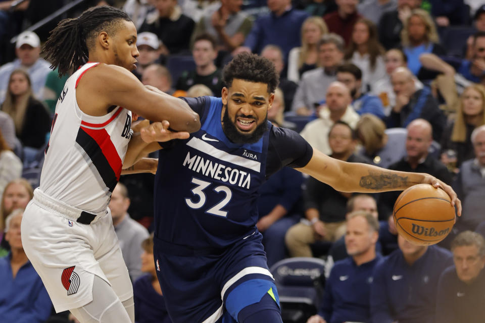 Minnesota Timberwolves forward Karl-Anthony Towns (32) goes to the basket around Portland Trail Blazers forward Jabari Walker, left, in the first quarter of an NBA basketball game Monday, March 4, 2024, in Minneapolis. (AP Photo/Bruce Kluckhohn)