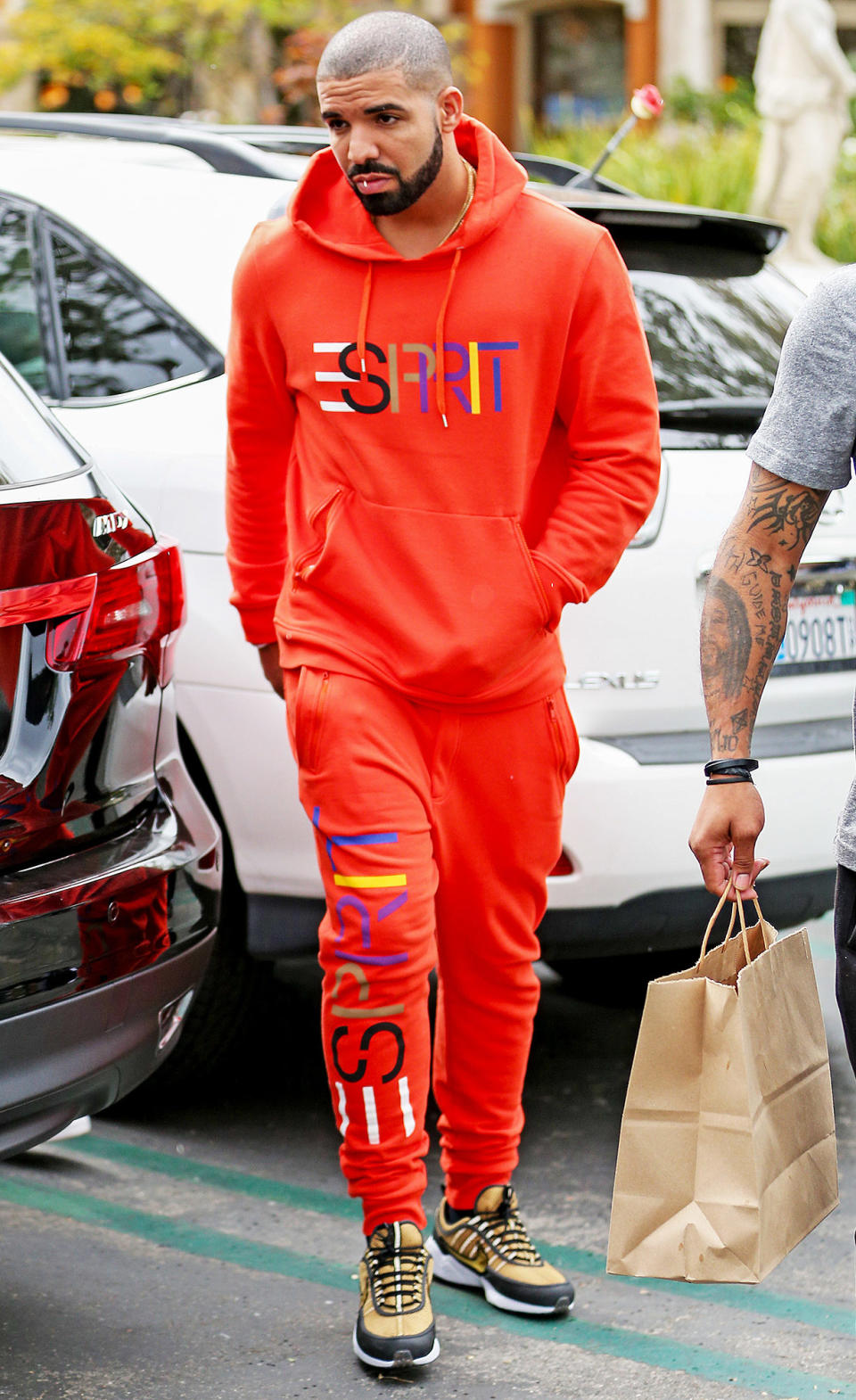 <p>Drake is channeling every '90s baby circa middle school in this neon orange Esprit sweatsuit paired with some khaki colored cross-trainers. All he's missing is a Tamagotchi keychain and some spiky, frosted tips.</p>