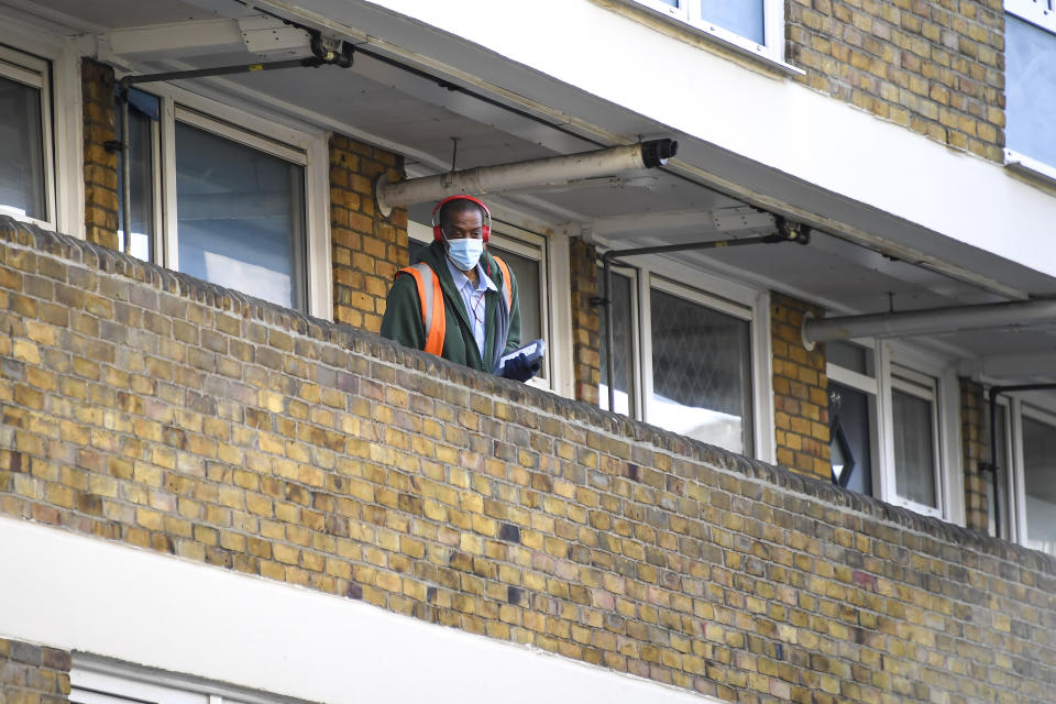 A postman is seen at work in East London as he wear a surgical mask, due to the Coronavirus outbreak, in London, Saturday, March 28, 2020. The public have been asked to self isolate, keeping distant from others to limit the spread of the contagious COVID-19 coronavirus. The new coronavirus causes mild or moderate symptoms for most people, but for some, especially older adults and people with existing health problems, it can cause more severe illness or death. (AP Photo/Alberto Pezzali)