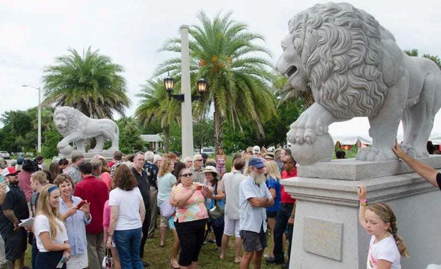 A crowd gathers around two new granite lion statues unveiled near the east side of the Bridge of Lions in St. Augustine during a ceremony on July 2, 2015.  