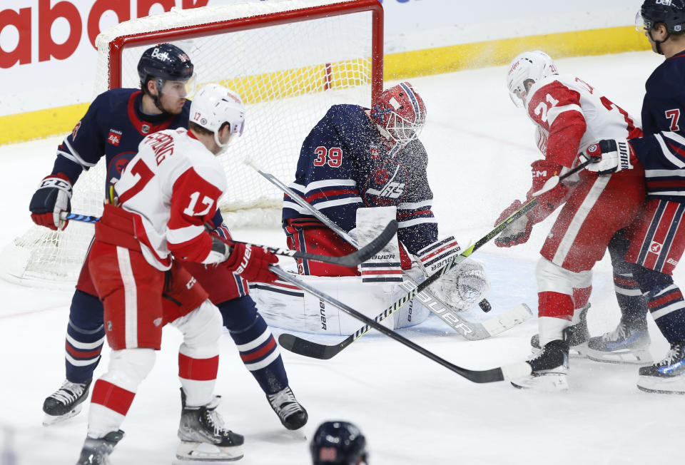 Winnipeg Jets goaltender Laurent Brossoit (39) makes a save against Detroit Red Wings' Austin Czarnik (21) during the second period of an NHL hockey game Wednesday, Dec. 20, 2023, in Winnipeg, Manitoba. (John Woods/The Canadian Press via AP)