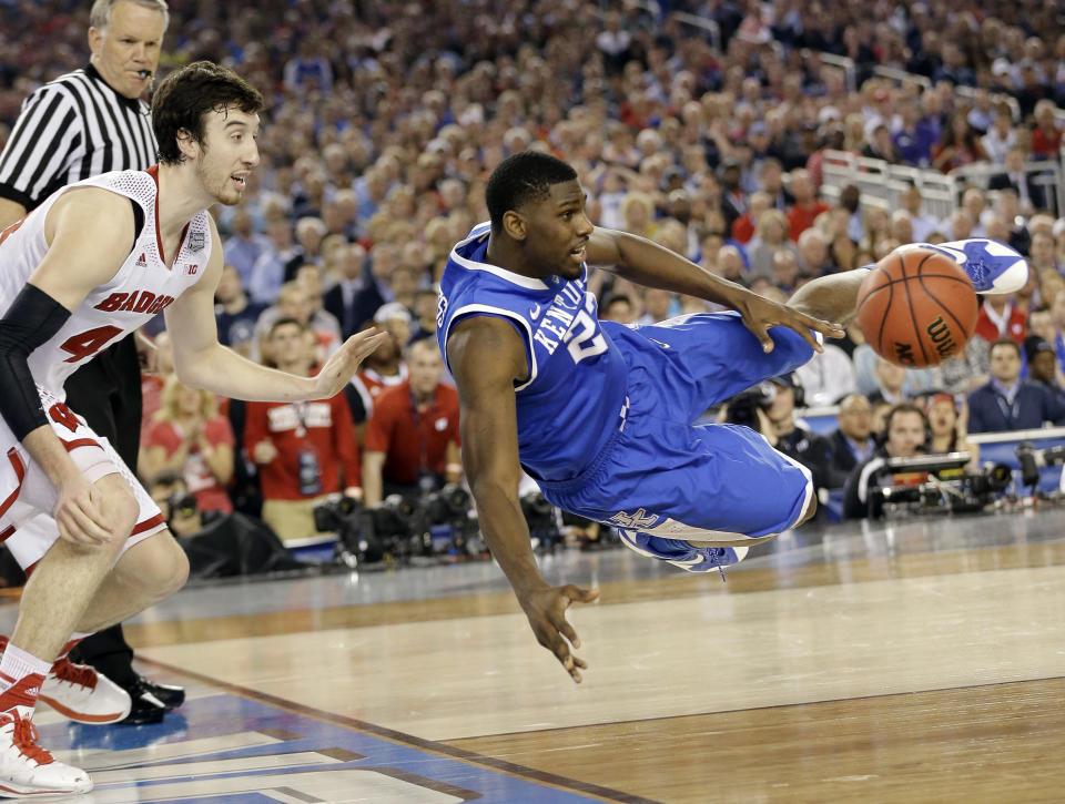 Kentucky forward Alex Poythress (22) saves the ball from going out as Wisconsin forward Frank Kaminsky (44) defends during the second half of the NCAA Final Four tournament college basketball semifinal game Saturday, April 5, 2014, in Arlington, Texas. (AP Photo/Eric Gay)