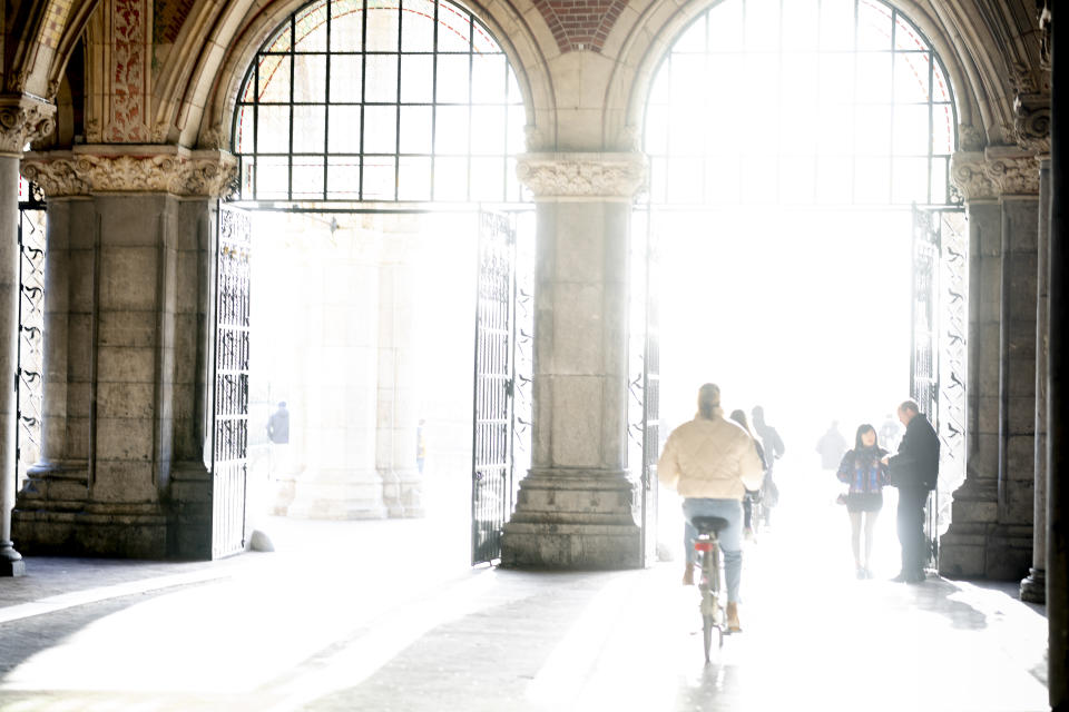 Bicyclists passing under the Rijksmuseum ride into the sunlight in Amsterdam, Monday, Feb. 6, 2023. The Vermeer exhibit Rijksmuseum unveils its blockbuster exhibition of 28 paintings by 17th-century Dutch master Johannes Vermeer drawn from galleries around the world. (AP Photo/Peter Dejong)