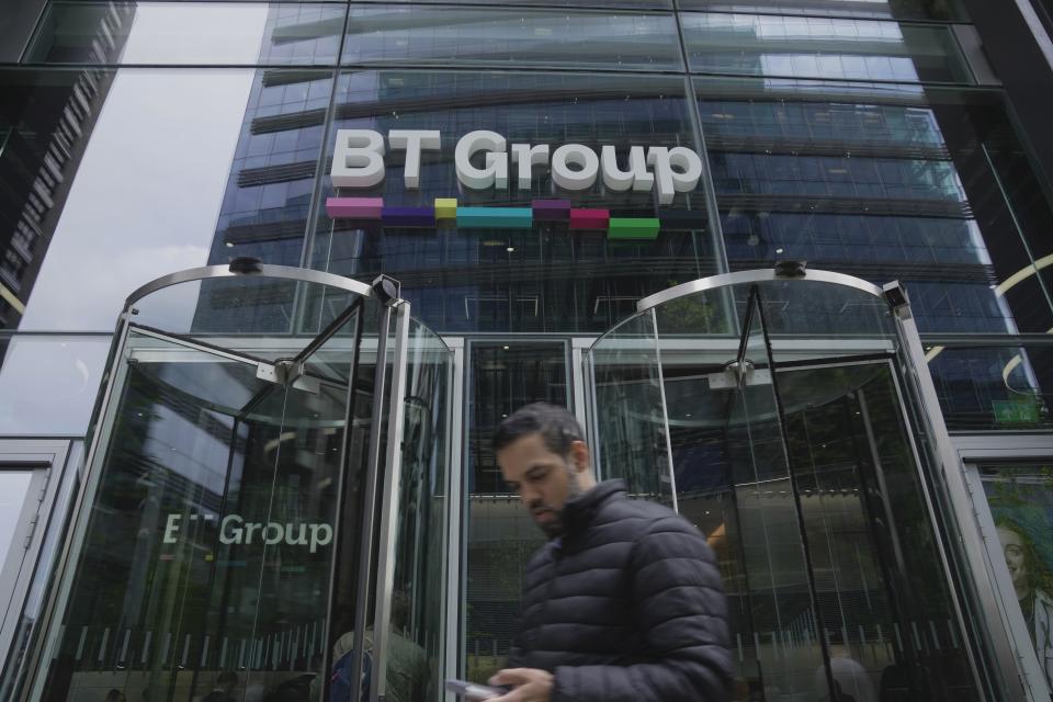 A man walks in front of the BT headquarters, in London, Thursday, May 18, 2023. U.K. telecom company BT Group said Thursday that it plans to shed up to 55,000 jobs by the end of the decade as part of an overhaul aimed at slimming down its workforce to slash costs. (AP Photo/Kin Cheung)